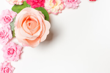 Frame made of rose flowers on white background. Top view with copy space.