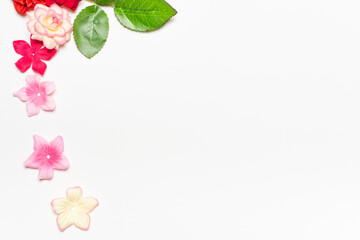 Frame made of rose flowers on white background. Top view with copy space.