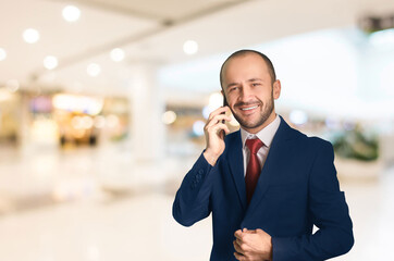 Young businessman talking on cell phone smiles