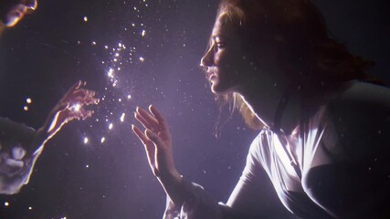 magic underwater shot of young woman floating in depth and looking on her reflection in water mirror