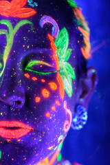 Mujer pintada glow in the dark, pintura de colores brillantes y artístico con luz ultravioleta