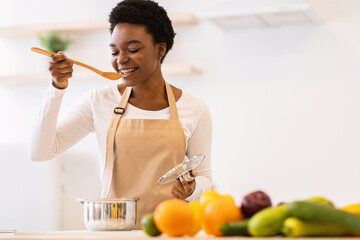 Black Lady Tasting Dinner In Kitchen Cooking Food At Home