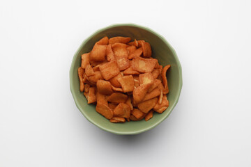 Crunchy and spicy snacks cracker in a bowl on white background. Malaysian traditional snacks, shrimps flavour cracker.