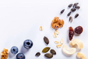 Seeds of sunflower, nuts, fruits and dried fruits on white background with copy space.