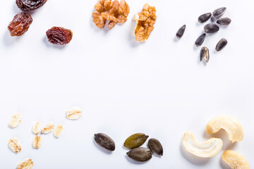 Seeds of sunflower, nuts, fruits and dried fruits on white background with copy space.