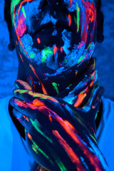 Hombre con pinturas glow in the dark, pintado de colores brillantes y artístico