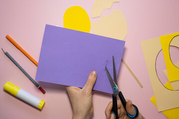 Naklejka premium Easter greeting card in egg shape. How to make children's paper craft. Step 5. Simple creative art project. Step by step instructions. Homemade easy paper applications. DIY concept.