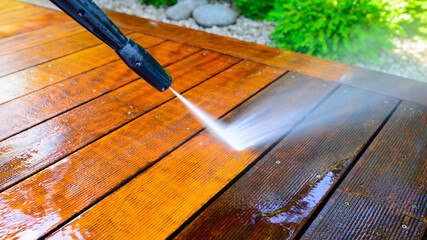 cleaning terrace with a power washer - high water pressure cleaner on wooden terrace surface - 410442178