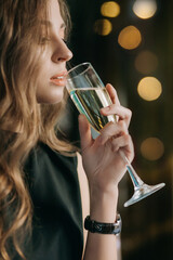 Romantic woman with long flying hair holds glass of champagne