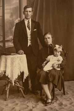 Germany - CIRCA 1930s: A family studio shot of married couple with a child in studio. Vintage art deco era photo