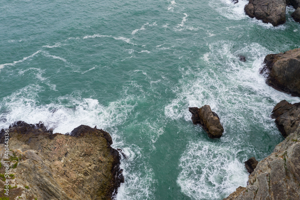 Poster top down view of sea water waves break on rocks