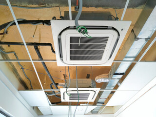 SELANGOR, MALAYSIA -MARCH 2, 2021: Installation of ceiling cassette air-condition. Mounted on the ceiling, and has the ability to cool the space more efficiently.