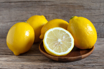 Fresh lemon and sliced on the wooden table.