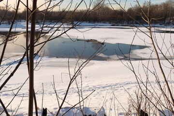 Winter landscape with river, tree and sun