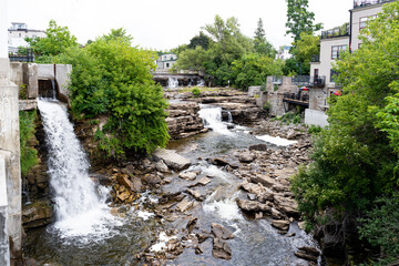 Almonte Falls, Ontario, Canada, a tiered and multiple segmented waterfall, surrounding small trees...