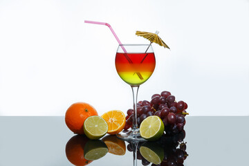 Bright summer cocktail in a glass and fruits