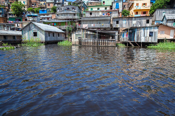 Wooden houses in flood of Rio Negro in sunny summer day. Manaus, Amazonas, Brazil. Concept of environment, ecology, climate change, global warming, natural disasters, nature.