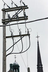un poteau électrique et le clocher d'une église
