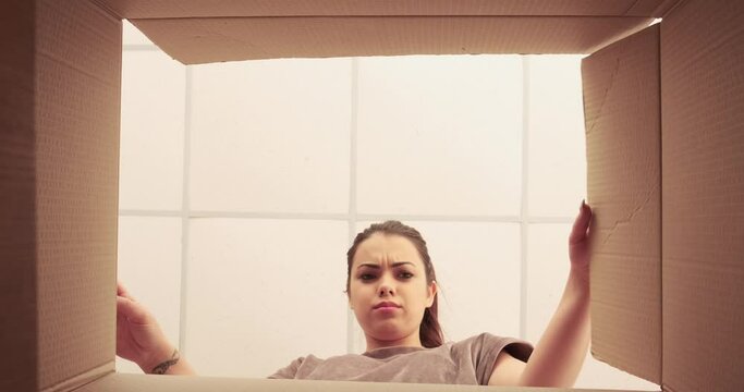 Woman upset on unpacking carton box at home