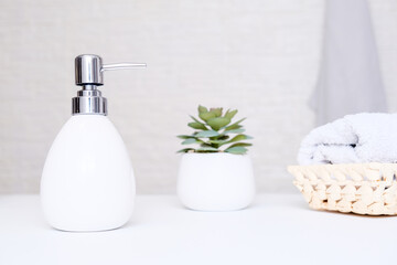 Obraz na płótnie Canvas Bathroom background, toilet accessories for hand and body care, liquid soap dispenser and towels against light background
