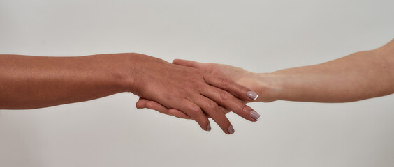 Fototapeta premium Close up of hand holding another hand. Gesture of salvation, guardianship isolated over light background