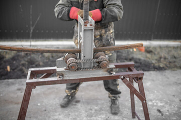 Workers bending metal at a construction site. Technology