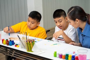 Asian disability boy learning color Painting in classroom with Autism girl in special school with...
