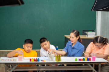 Asian disability boy learning color Painting in classroom with Autism girl in special school with female teacher.