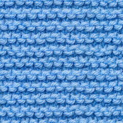 Blue knitted fabric seamless pattern for borderless fill. Knitted fabric repeating pattern for background close up.