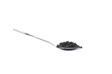 Small spoon with black tea heaped on a white background. Healthy food concept.