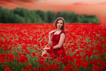 girl in a red dress on a poppy field with a basket in her hands