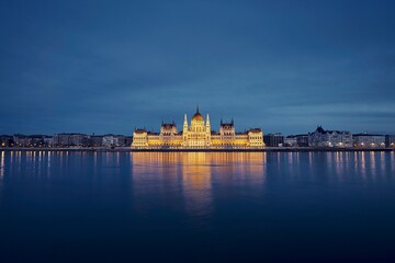Reflection of illuminated Hungarian Parliament building in Danube River. Budapest skyline at dusk, Hungary.