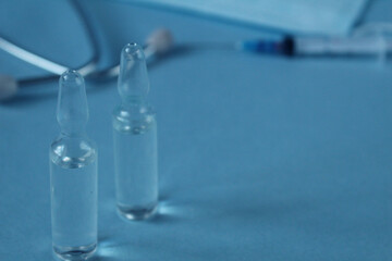 glass vials against the background of a syringe, masks blue with copyspace