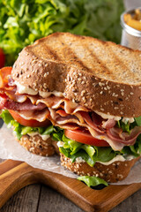 BLT sandwich and fries on wooden table