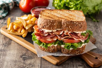 BLT sandwich and fries on wooden table