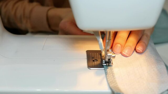Sewing machine needle in motion. Close-up of a sewing machine needle moves up and down quickly. Fabric sewing process. sewing, needlework concept.