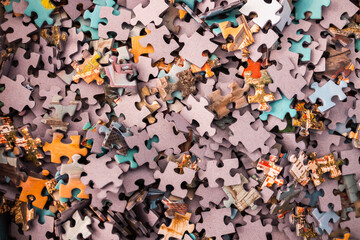 Pile of puzzle pieces close up. A puzzle is a game, problem, or toy that tests a person's ingenuity or knowledge.