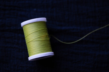 spool of green thread on black background