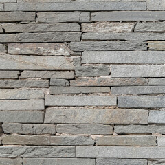 rough grey slate stone wall closeup, textured pattern background