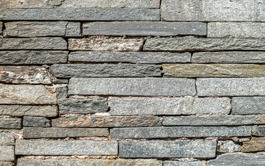 rough grey slate stone wall closeup, textured pattern background