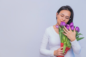 Mujer Latina sosteniendo un ramo de tulipanes.