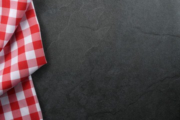 Classic italian cooking background - red checkered tablecloth on a vintage black stone kitchen...