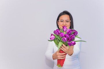 Mujer Latina sosteniendo un ramo de tulipanes.
