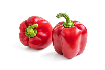 Two red shiny bell peppers on a white background