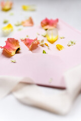 rosa und gelbe Blüten als Detail auf einem rosa Briefumschlag mit weißem Seidenband im Vordergrund | Hochzeitseinaldung, Papeterie,, fine art, romantisch