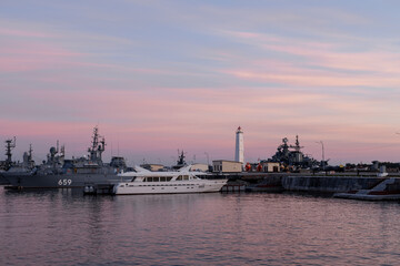 A parade boat for the Russian Navy against the background of a wooden lighthouse in the Petrovskaya...