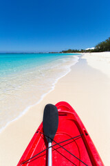 Bunte rote Kajaks mit Paddeln an einem tropischen Strand am Sommertag. Seven Mile Beach, Grand Cayman, Kaimaninseln, Karibik