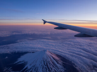 飛行機から朝焼けの富士山を眺める