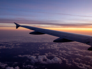 Obraz na płótnie Canvas 飛行機から見る朝焼けに染まる世界