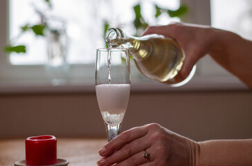 white sparkling wine poured from bottle to glass